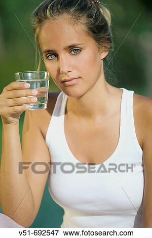 Stock Photo - Young woman holding a glass of water. Fotosearch