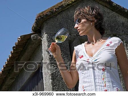 Young woman holding a glass of white wine Spain View Large Photo Image Stock Image - Young woman holding a glass of white wine Spain. Fotosearch
