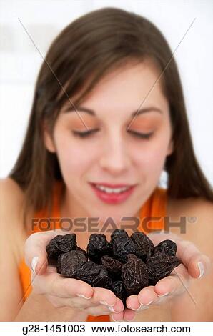Young woman holding a handful of dried prunes View Large Photo Image Stock Image - Young woman holding a handful of dried prunes. Fotosearch