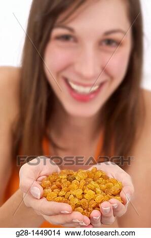 Young woman holding a handful of dry grapes View Large Photo Image Picture - Young woman holding a handful of dry grapes. Fotosearch