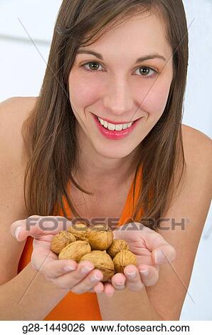 Young woman holding a handful of nuts View Large Photo Image Stock Photograph - Young woman holding a handful of nuts. Fotosearch