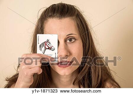 Young woman holding a? joker? playing card View Large Photo Image Stock Image - Young woman holding a? joker? playing card. Fotosearch