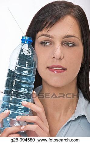 Stock Image - young woman holding a large bottle of mineral water. Fotosearch