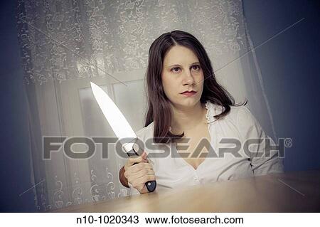 Young woman holding a large knife View Large Photo Image Stock Image - Young woman holding a large knife. Fotosearch