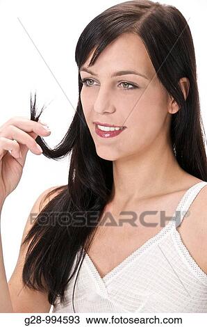 young woman holding a lock of her hair inspecting it for problems View Large Photo Image Stock Image - young woman holding a lock of her hair inspecting it for problems. Fotosearch
