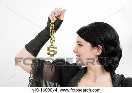 Young woman holding a necklace with an American dollar sign attached View Large Photo Image Picture - Young woman holding a necklace with an American dollar sign attached. Fotosearch