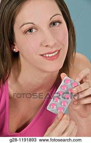 Young woman holding a pack of pink tablets for medical treatment View Large Photo Image Stock Image - Young woman holding a pack of pink tablets for medical treatment. Fotosearch