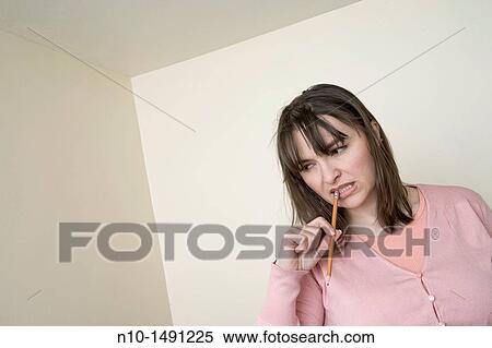 Stock Photography - Young woman holding a pencil. Fotosearch