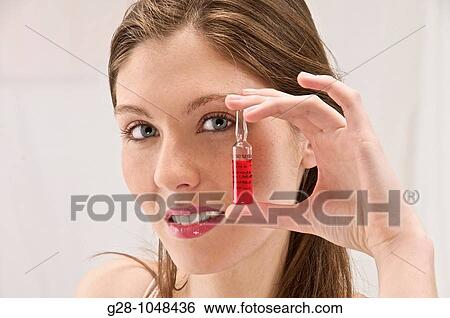 young woman holding a phial of red vitamin B12 agaist anemy View Large Photo Image Stock Photograph - young woman holding a phial of red vitamin B12 agaist anemy. Fotosearch