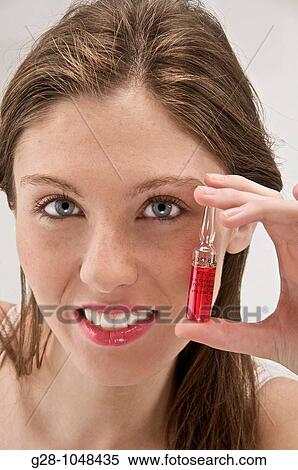 young woman holding a phial of red vitamin B12 agaist anemy View Large Photo Image Stock Photography - young woman holding a phial of red vitamin B12 agaist anemy. Fotosearch