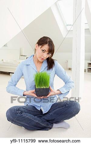 Stock Photo - Young woman holding a pot plant.. Fotosearch
