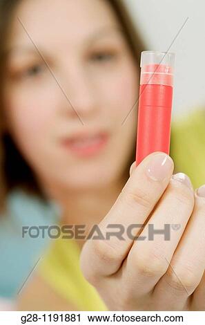 Young woman holding a red homeopathy tube close up View Large Photo Image Stock Image - Young woman holding a red homeopathy tube close up. Fotosearch