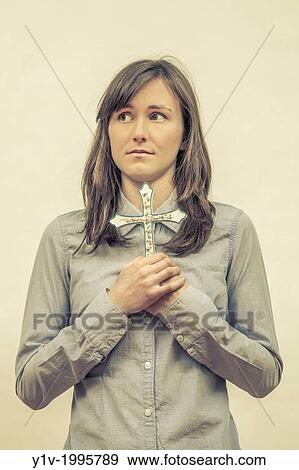 Young woman holding a religious cross. View Large Photo Image Stock Photo - Young woman holding a religious cross.. Fotosearch
