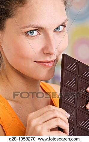 young woman holding a tablet of dark chocolate View Large Photo Image Stock Image - young woman holding a tablet of dark chocolate. Fotosearch