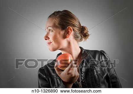 Stock Image - Young woman holding an apple. Fotosearch