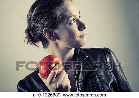 Stock Photo - Young woman holding an apple. Fotosearch