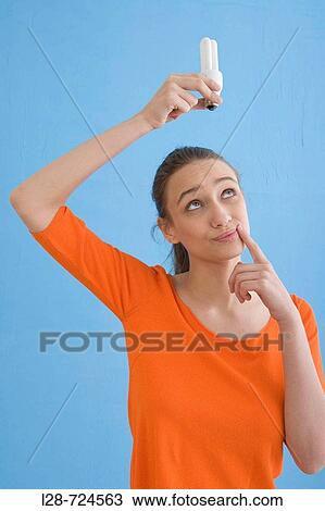 Young woman holding compact fluorescent bulb, portrait View Large Photo Image Stock Image - Young woman holding compact fluorescent bulb, portrait. Fotosearch