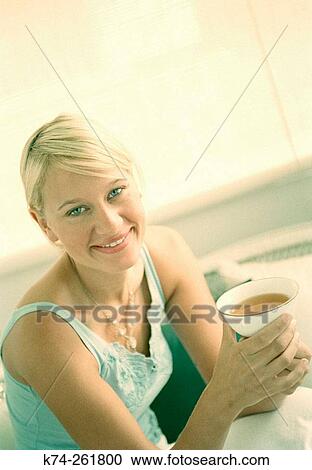 Young woman holding cup of tea View Large Photo Image Stock Image - Young woman holding cup of tea. Fotosearch