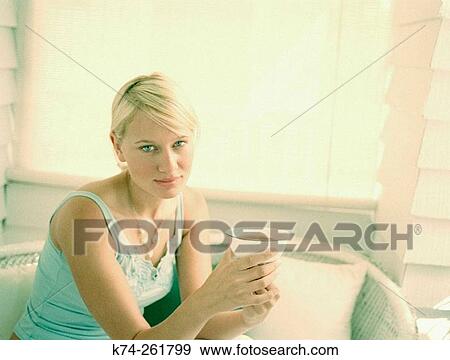 Young woman holding cup of tea View Large Photo Image Stock Photo - Young woman holding cup of tea. Fotosearch