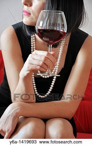 Young woman holding glass of red vine View Large Photo Image Stock Image - Young woman holding glass of red vine. Fotosearch