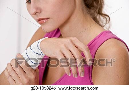young woman holding her bandaged arm and suffering View Large Photo Image Stock Photography - young woman holding her bandaged arm and suffering. Fotosearch