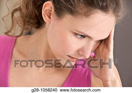 young woman holding her forehead suffering from a headache View Large Photo Image Stock Image - young woman holding her forehead suffering from a headache. Fotosearch