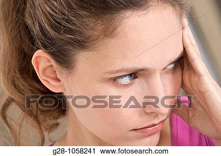 young woman holding her forehead suffering from a headache View Large Photo Image Stock Image - young woman holding her forehead suffering from a headache. Fotosearch
