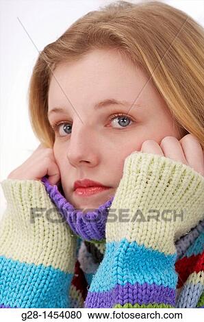 Young woman holding her multi colored pullover over her chin and ears for cold or ear ache View Large Photo Image Stock Image - Young woman holding her multi colored pullover over her chin and ears for cold or ear ache. Fotosearch
