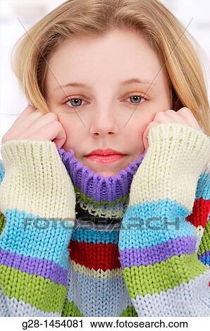 Young woman holding her multicolored pullover over her chin and ears or cold or aching ears View Large Photo Image Stock Image - Young woman holding her multicolored pullover over her chin and ears or cold or aching ears. Fotosearch