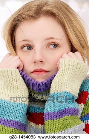 Young woman holding her multicolored pullover over her chin and ears for cold or aching ears View Large Photo Image Stock Image - Young woman holding her multicolored pullover over her chin and ears for cold or aching ears. Fotosearch