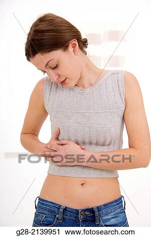 Young woman holding her stomach and her ribs on the side for pain View Large Photo Image Stock Image - Young woman holding her stomach and her ribs on the side for pain. Fotosearch