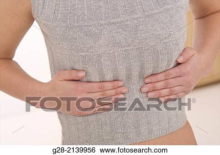 young woman holding her stomach and ribs for pain View Large Photo Image Stock Photograph - young woman holding her stomach and ribs for pain. Fotosearch