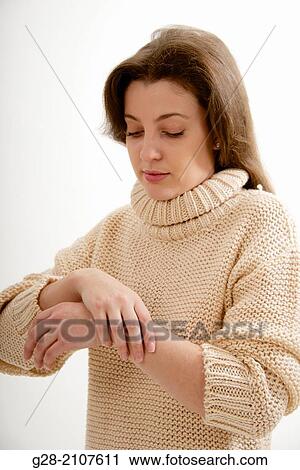 Young woman holding her wrist for pain, in a beige pull over View Large Photo Image Stock Image - Young woman holding her wrist for pain, in a beige pull over. Fotosearch