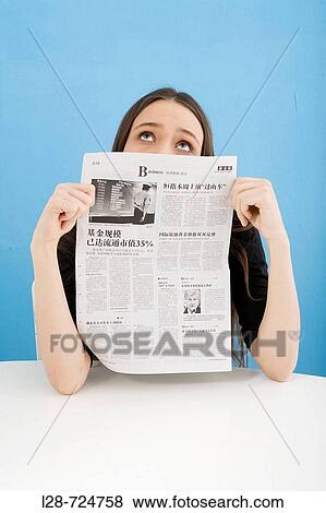 Stock Photo - Young woman holding newspaper, close-up. Fotosearch
