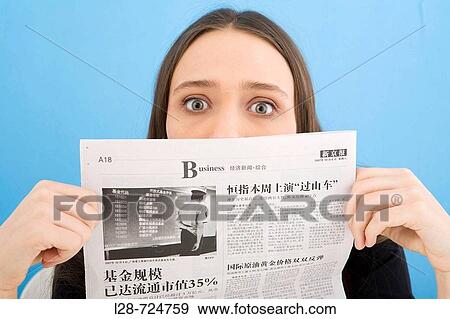 Stock Photo - Young woman holding newspaper, close-up. Fotosearch