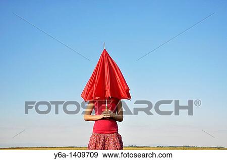 Young woman holding red umbrella View Large Photo Image Stock Photo - Young woman holding red umbrella. Fotosearch