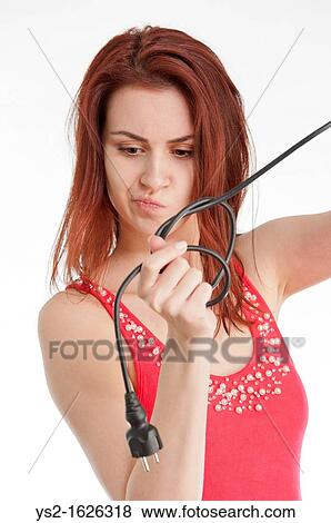 Stock Photo - Young woman holding tangled electric cable. Fotosearch