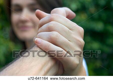 Picture - Young Woman Holding the Hand of a Man. Fotosearch