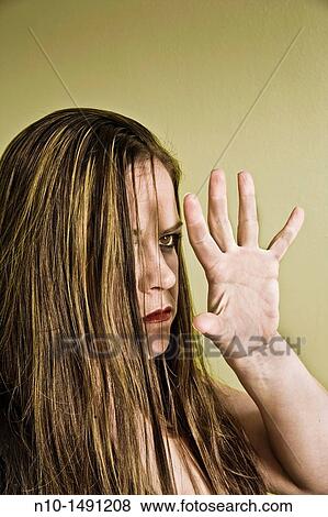 Stock Photo - Young woman holding up her hand. Fotosearch