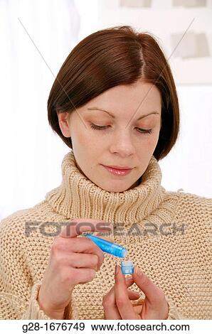 Young woman in a beige turtleneck pullover, counting homeopathic pills out of a blue tube View Large Photo Image Stock Photo - Young woman in a beige turtleneck pullover, counting homeopathic pills out of a blue tube. Fotosearch