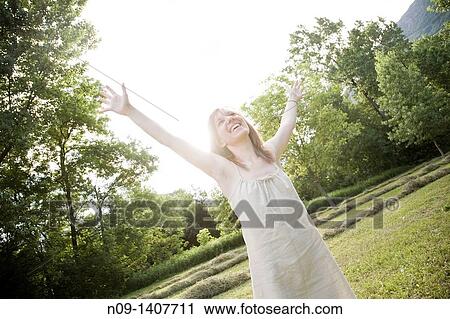 Young woman in a field View Large Photo Image Stock Image - Young woman in a field. Fotosearch