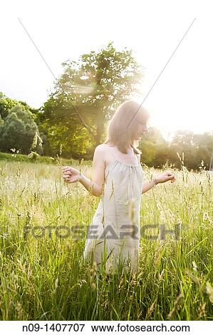 Stock Photo - Young woman in a field. Fotosearch