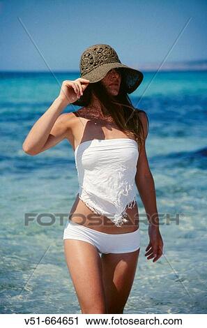 Young woman in a hat going out from the water. View Large Photo Image Stock Image - Young woman in a hat going out from the water.. Fotosearch