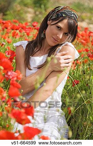 Stock Photo - Young woman in a poppy field.. Fotosearch