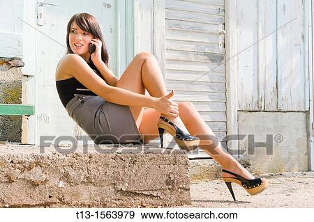 Young woman in a short mini-dress is talking using cellular phone View Large Photo Image Stock Photo - Young woman in a short mini-dress is talking using cellular phone. Fotosearch