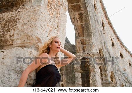 Stock Image - Young woman in ancient environment. Fotosearch