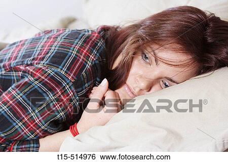 Stock Photograph - Young woman in bed. Fotosearch