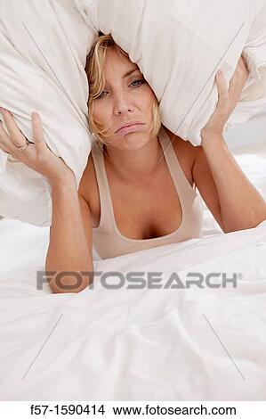 Young woman in bed with pillow on her head View Large Photo Image Picture - Young woman in bed with pillow on her head. Fotosearch