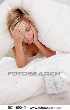 Young woman in bed with pillow on her head View Large Photo Image Picture - Young woman in bed with pillow on her head. Fotosearch