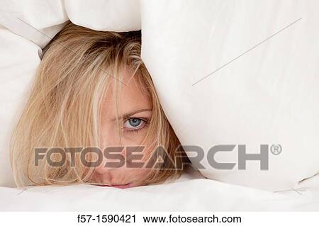 Young woman in bed with pillow on her head View Large Photo Image Stock Image - Young woman in bed with pillow on her head. Fotosearch
